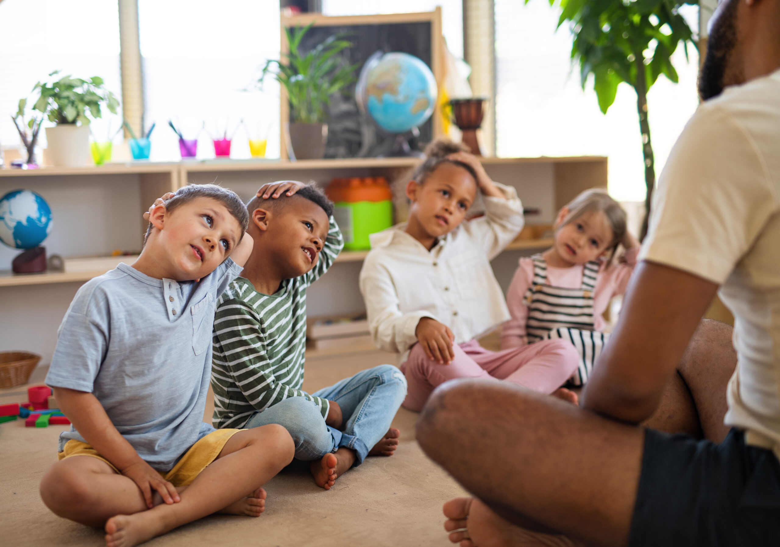 Nursery practitioner with a group of young children