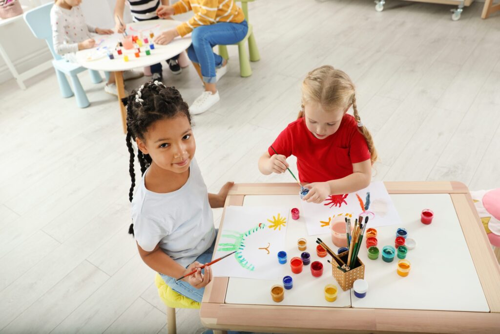 Young children painting together at a table