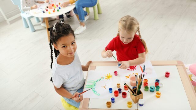 Young children painting together at a table