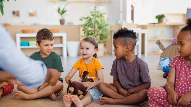 Diverse group of young children sitting together on a nursery floor