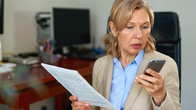 Manager reading a document while on a phone call