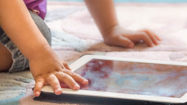 Close-up of a young child's hands using a tablet